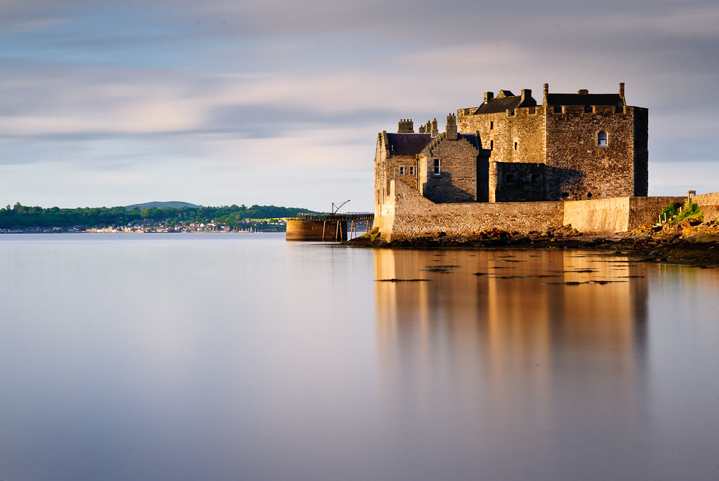 Blackness Castle at the water's edge, reflected in calm waters